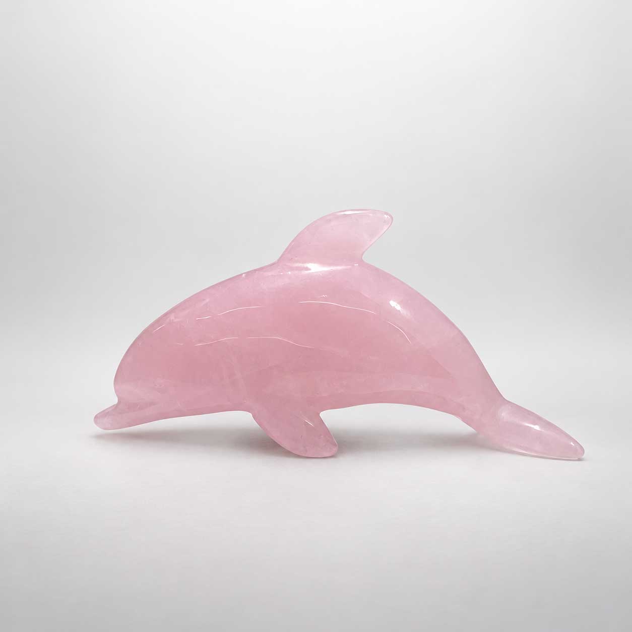 Delfinfigur aus zartrosa Rosenquarz mit natürlichen Steinstrukturen